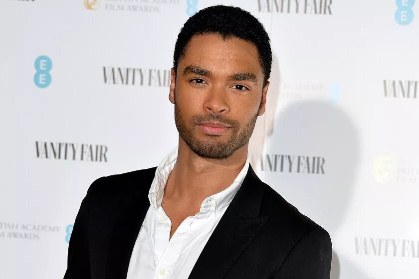 Regé-Jean Page posing in a suit on a red carpet