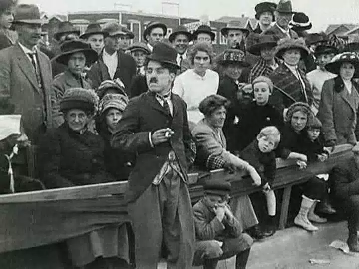 Charlie Chaplin and a crowd of real people watching the races.