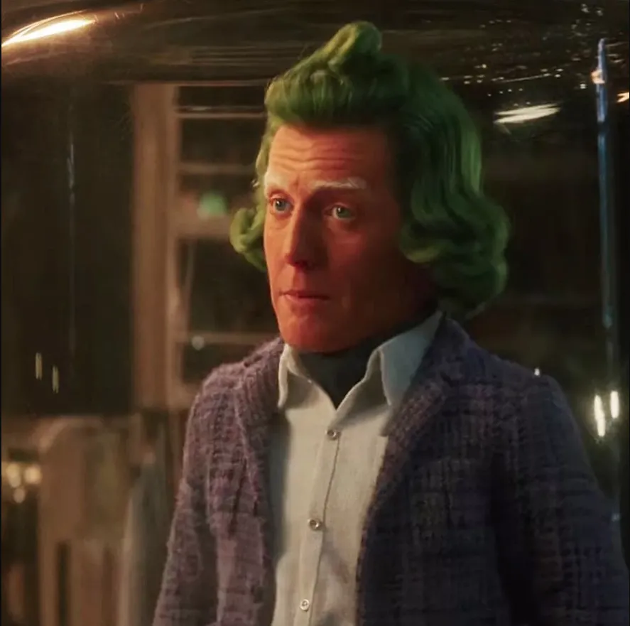 Hugh Grant como Oompa Loompa, atrapado en un frasco de vidrio.