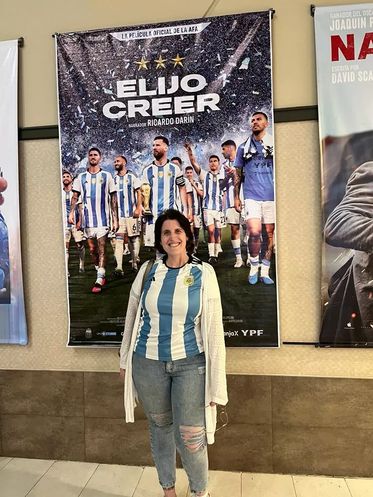 A person standing in front of a poster

Description automatically generated