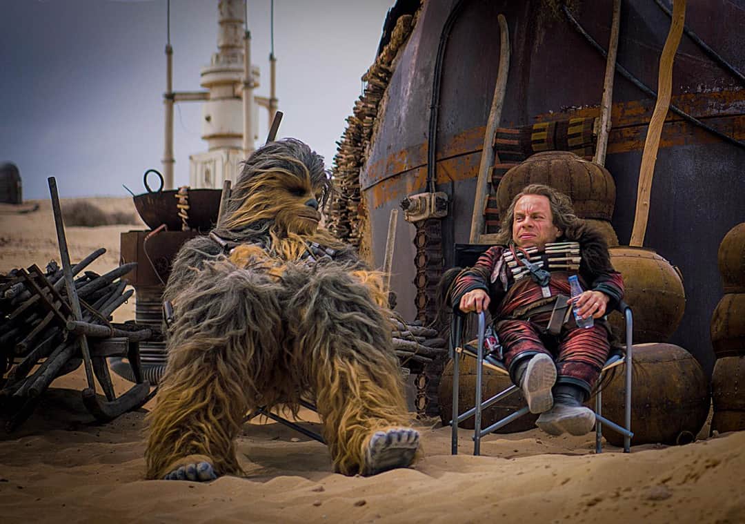 Joonas Suotamo (Chewie) and Warwick Davis (Weazel) relax between takes on  the set of 