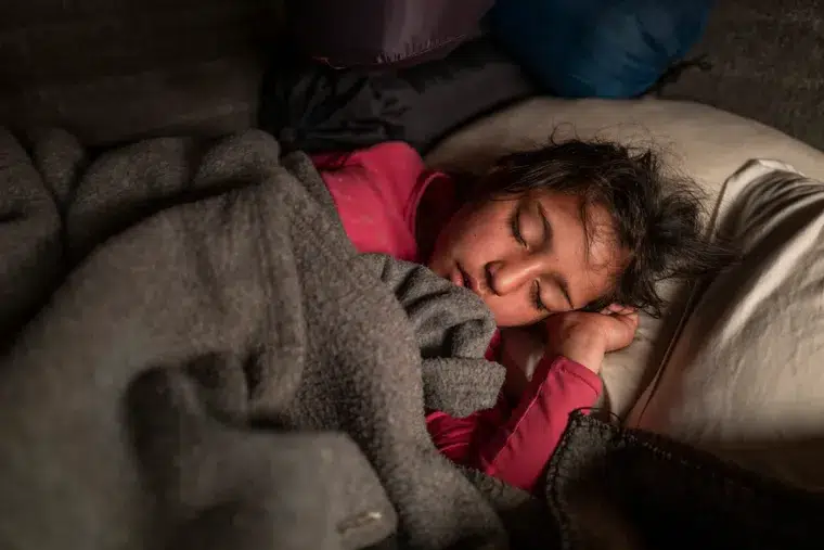 Una niña refugiada afgana duerme en una litera en un centro One-stop en Adasevci, cerca de ...