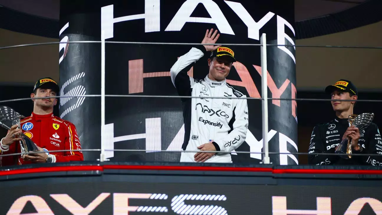3 men waving from a podium