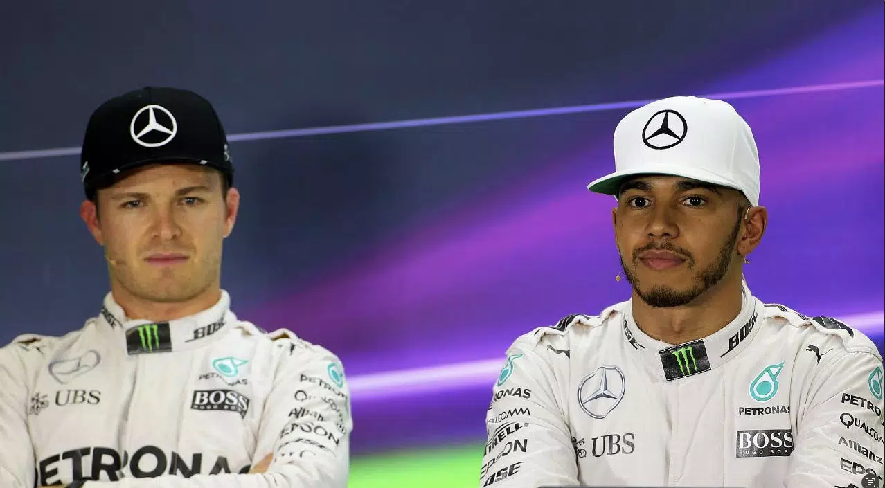 2 men in matching race suits sit side by side